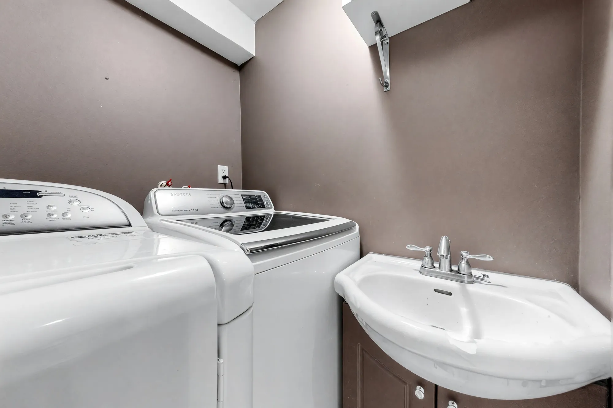The laundry shown cleared: the washer, the dryer and a laundry sink