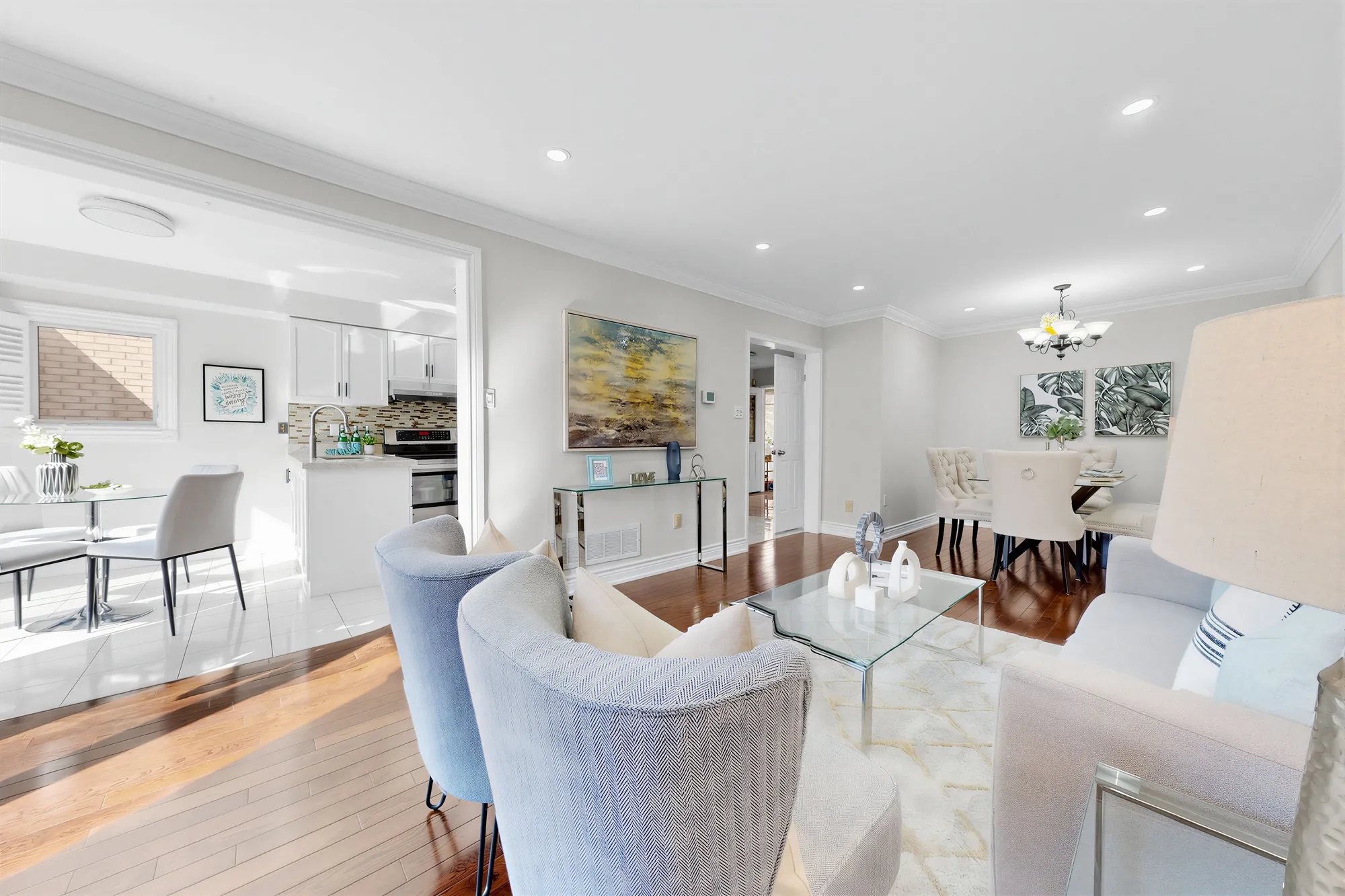 From the breakfast nook: the living room's chairs and glass table, the dining room beyond, the kitchen at the left